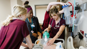 Nursing students and professor working with simulated patient